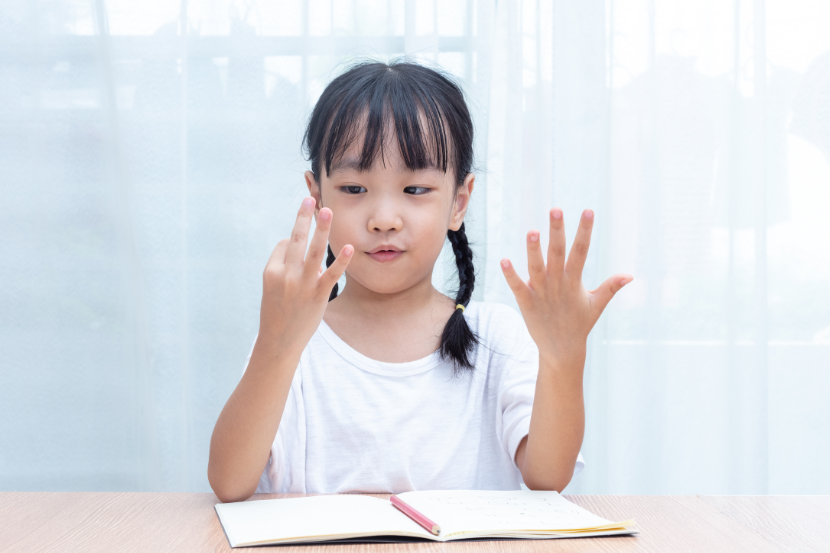menina estudando matemática e contando com os dedos