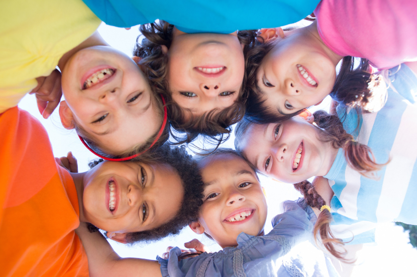 diversas crianças abraçadas e sorridentes