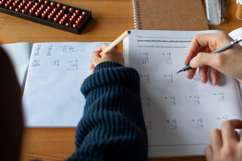 responsável ajudando filho na tarefa de matemática