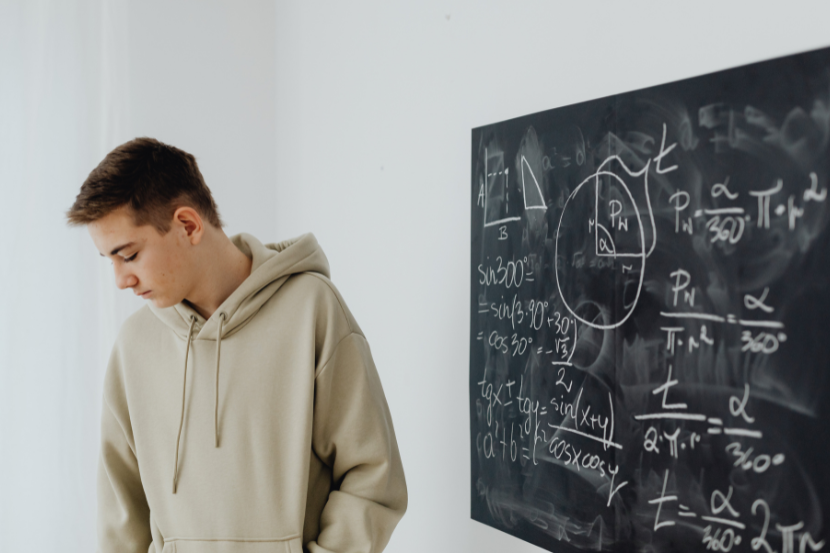 estudante frustrado por não conseguir entender cálculo de matemática no quadro