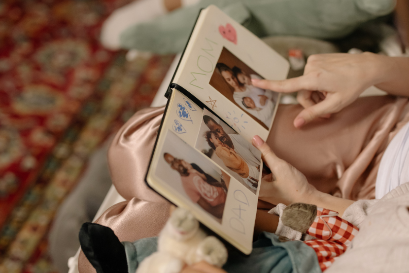 mãe mostra álbum de fotos da família para filho pequeno