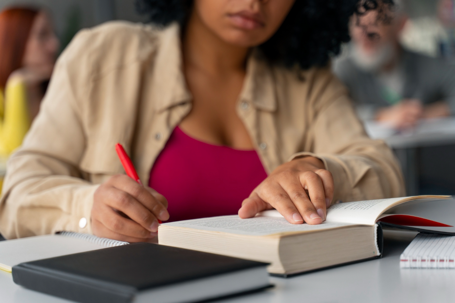 Candidata estudando para pós-graduação para concurso com livros e anotações.