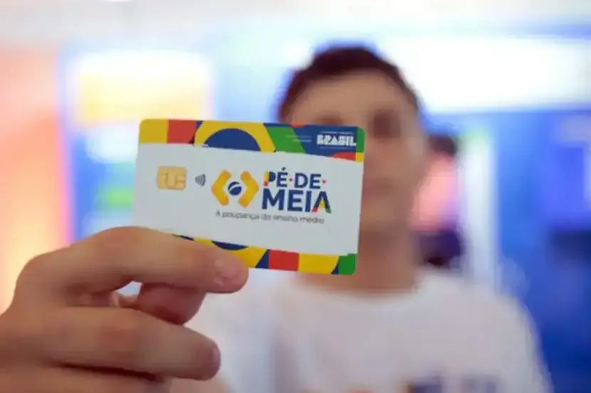jovem beneficiado mostrando cartão do pé-de-meia calendário 