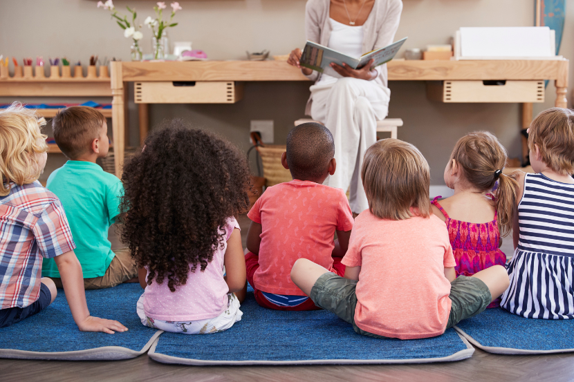 crianças sentadas ouvindo história como atividade complementar de escola em tempo integral