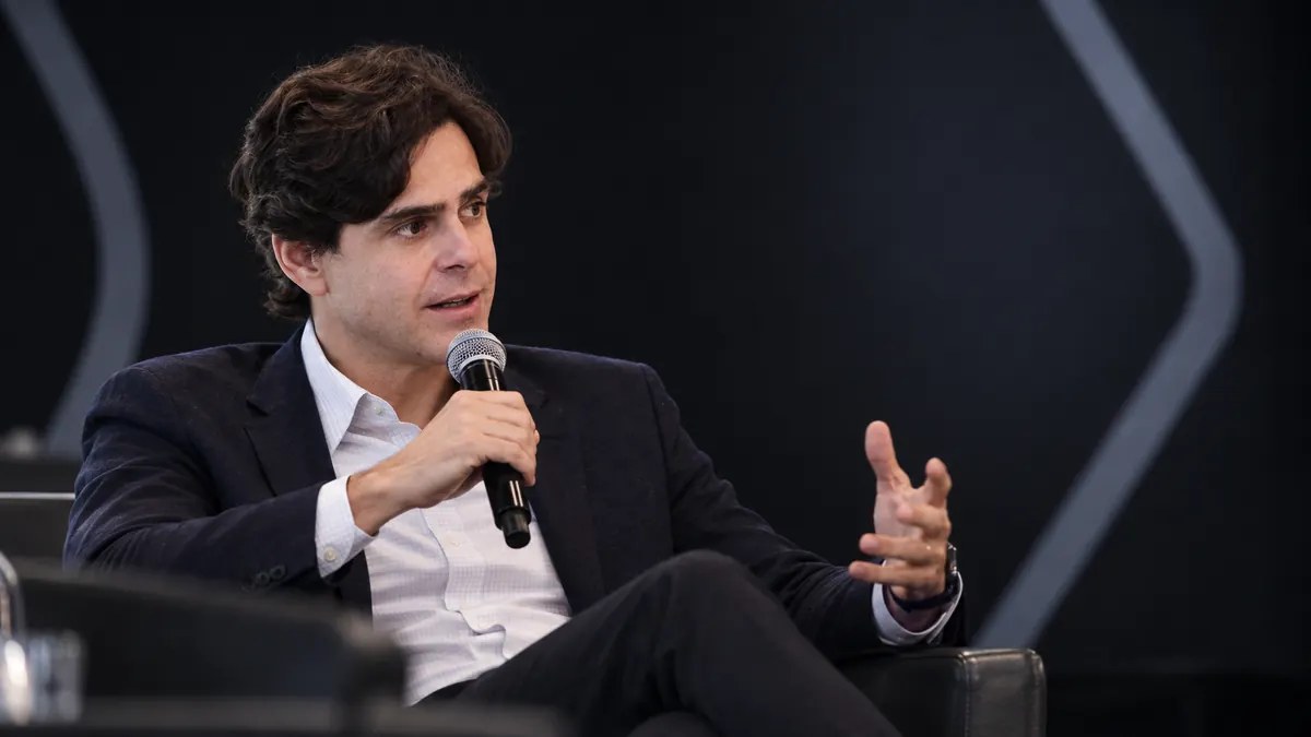Guilherme Benchimol durante conversa sobre negócios em evento empresarial