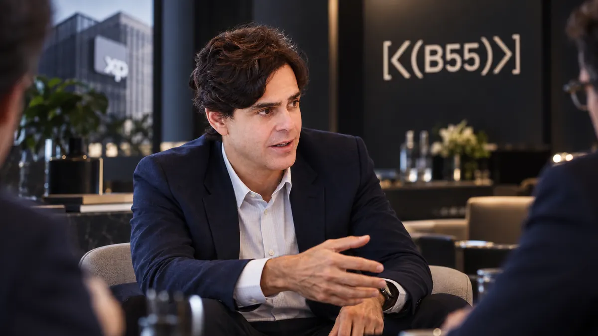 Guilherme Benchimol em conversa empresarial com referência visual à XP
