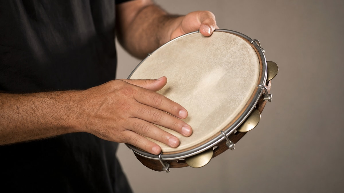 Posição das mãos no pandeiro Mãos demonstrando como segurar o pandeiro e percutir a pele