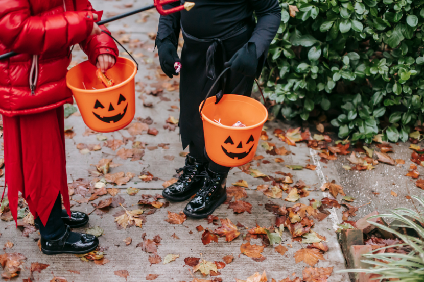 crianças fantasiadas de halloween carregam baldes de doces para brincadeira de doces ou travessuras